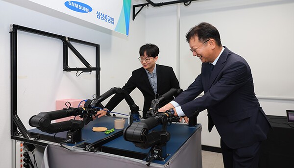 최성안 삼성중공업 대표이사 부회장이 부산대학교 양팔모방학습로봇을 직접 체험해 보고 있는 모습